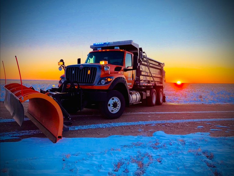 A CDOT snow plow prepares for snow removal in eastern Colorado as the sun rises.